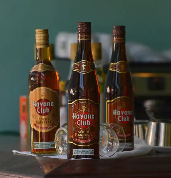 tri boce Havana club ruma na drvenom stolu