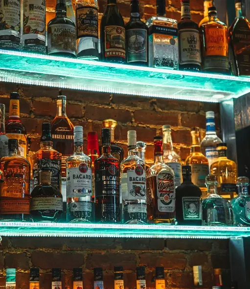 Razne boce alkoholnih pića na staklenim policama
