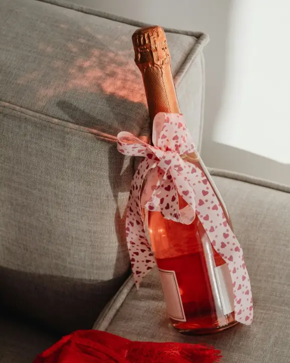 Rose pjenušavo vinu na koje je zavezana vrpca sa srcima