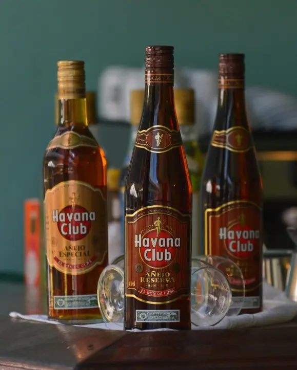 tri boce Havana club ruma na drvenom stolu