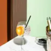 čaša gin tonika sa ukrasnom kriškom naranče i crna slamka