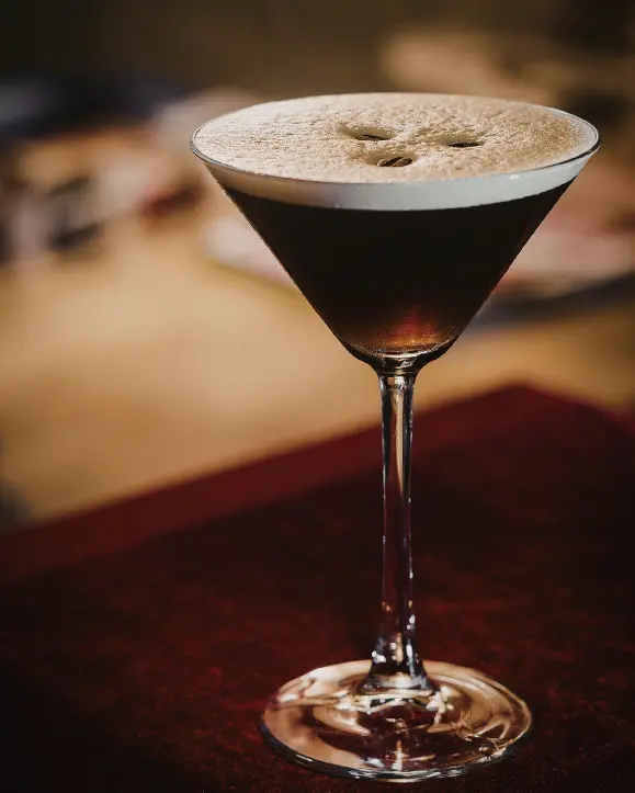 Vanilla Espresso Martini s Absolut Vanilia votkom poslužen u elegantnoj cocktail čaši s bogatom kremastom pjenom i zrnima kave na vrhu