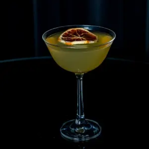 Elegantna koktel čaša coupe od prozirnog stakla poslužena s citrusnim koktelom i dekoracijom od sušene naranče, idealna za martini, sour i druge. klasične čaše za koktele